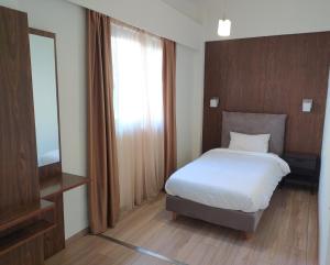 
a bedroom with a bed and a dresser at Du Lac in Agios Nikolaos

