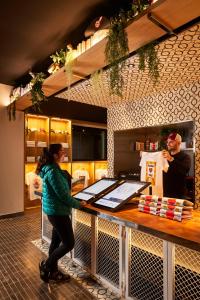 a woman standing at a counter in a restaurant at Mama Shelter Paris West in Paris