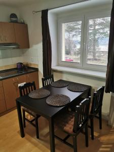 einen schwarzen Tisch und Stühle in einer Küche in der Unterkunft Apartmán Romance in Lipno nad Vltavou