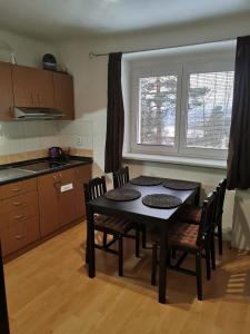 kuchnia ze stołem i krzesłami w kuchni w obiekcie Apartmán Romance w mieście Lipno nad Vltavou