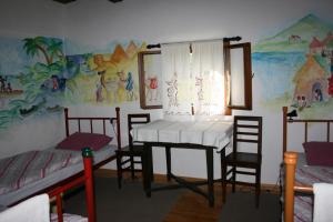 a room with a table and chairs and a mural at Guest House Sunčano Selo in Jagnjedovec
