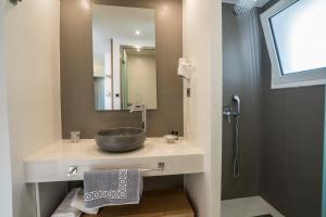 a bathroom with a sink and a mirror at Atrion Resort Hotel in Agia Marina Nea Kydonias