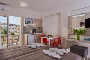 a bedroom with a bed and a kitchen with a table at Atrion Resort Hotel in Agia Marina Nea Kydonias
