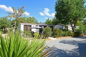 una casa con sombrilla y algunas plantas en Camping Domaine Du Golfe De Saint Tropez, en Grimaud