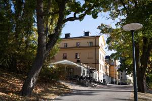 a street scene with trees and a building at STF af Chapman & Skeppsholmen in Stockholm