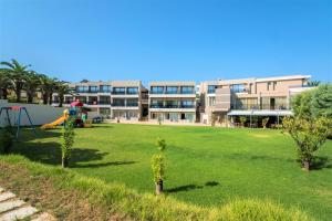 a large yard with a playground in front of a building at Atrion Resort Hotel in Agia Marina Nea Kydonias