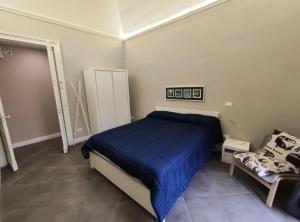 een slaapkamer met een blauw bed en een stoel bij Felt in love in Catania in Catania