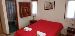 a bedroom with a red bed with towels on it at La Gracia in Salta
