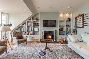 a living room with a couch and a fireplace at Spectacular Penthouse , 100 yds to Old Course , Balcony in St Andrews
