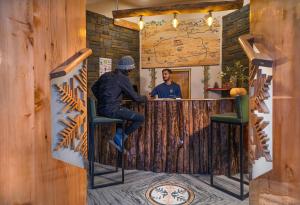 a man sitting at a bar in a restaurant at Zostel Plus Bir in Bīr