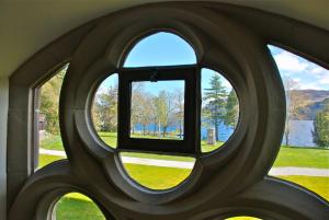 - une fenêtre dans un bâtiment avec vue sur le lac dans l'établissement Highland Club Direct, à Fort Augustus