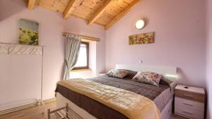 a bedroom with a large bed in a room with a window at Istrian villa Orbanići with private pool for up to 12 persons in Orbanići +40 photos