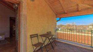 a porch with two chairs and a balcony with a view at Istrian villa Orbanići with private pool for up to 12 persons in Orbanići