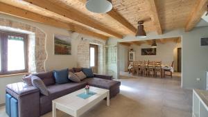 a living room with a couch and a table at Istrian villa Orbanići with private pool for up to 12 persons in Orbanići