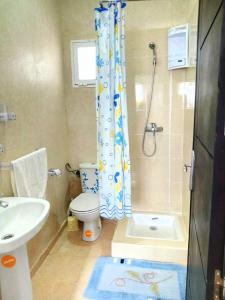 uma casa de banho com um chuveiro, um WC e um lavatório. em chic appart vue sur piscine em Tânger