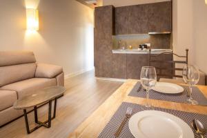 a living room with a couch and a table with wine glasses at Apartamentos Sevilla Este by QHotels in Seville +12 photos
