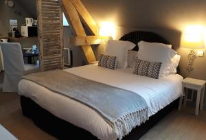 a bedroom with a large bed with white sheets and pillows at Chambres d'Hôtes Maison La Porte Rouge in Niort