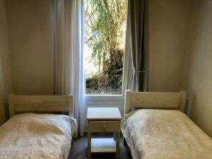 2 camas en una habitación con ventana en Palmas de la Pedrera maravillosa casa, en Rocha