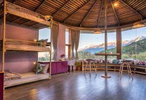 a room with bunk beds and a view of mountains at Zostel Plus Bir in Bīr