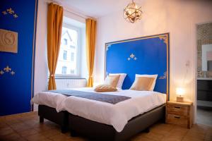 a bedroom with a large bed with a blue headboard at Zythogite, 23 personnes, 9 chambres, 6 salles de bain, bbq, jacuzzi, jardin, billard in Tintigny