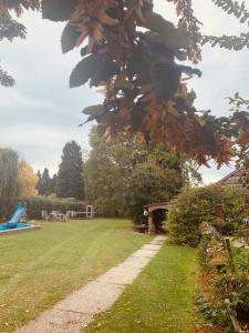 un jardin avec un sentier et un parc avec une aire de jeux dans l'établissement Leuk vakantiehuisje 6p, à Brunssum