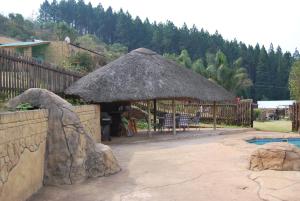 un patio con una sombrilla grande y una piscina en Valley View at Rocklog Farm, en Howick