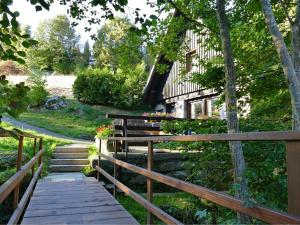 un camino de madera que conduce a una casa con una valla de madera en Converted old mill in St Georgen inBlack Forest, en St. Georgen im Schwarzwald