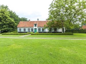 貝爾內姆的住宿－Beautiful farmhouse in Beernem with big garden，前面有绿色草坪的房子