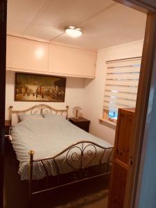 1 dormitorio con cama y ventana en Leuk vakantiehuisje 6p en Brunssum