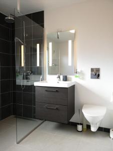 a bathroom with a sink and a toilet and a mirror at Tórshavn Apartment - Great View in Tórshavn