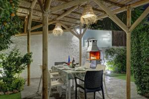un patio con mesa y sillas bajo una pérgola de madera en Villa Conchita By Seric,15´ walking to the beach, en Torremolinos