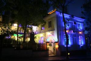 a house decorated in blue and green lights at night at Rimini Club Inn & Suites in Shumen