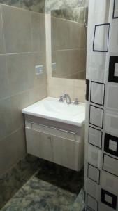 a bathroom with a sink and a mirror at LAS MACLURAS in Mar de Ajó