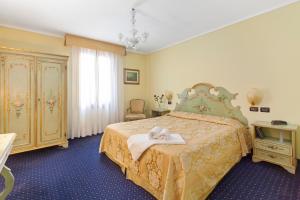 une chambre d'hôtel avec un lit et une commode dans l'établissement Hotel Malibran, à Venise