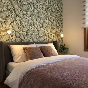 una camera da letto con un grande letto e carta da parati floreale di Apartman Lidija Zlatibor a Zlatibor
