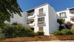 a white building with balconies and plants at Apartment Sao Rafael in Albufeira