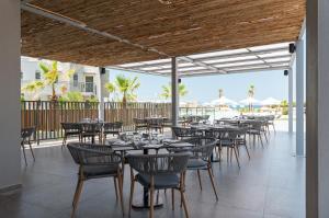 a row of tables and chairs on a patio at Portes Lithos Luxury Resort in Nea Potidaea