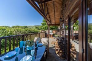 a deck with a table and chairs on a porch at Oaks Log Cabins in Swanage