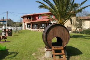 un barril de madera sentado en el césped frente a una casa en Apartamentos Vega Rodiles el balcón, en Villaviciosa