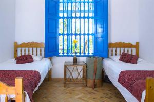 2 camas en una habitación con ventana azul en Casazul Casa de Campo, en Fredonia
