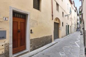 Un callejón vacío con una puerta de madera en un edificio. en Granduca Apartment in Top Location, en Florencia 83 fotos más