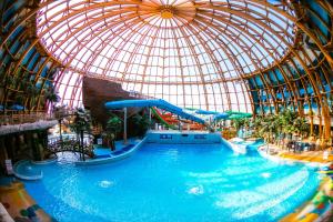 an indoor water park with a domed ceiling at Piterland Hotel in Saint Petersburg
