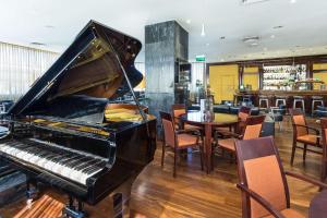 a piano in a restaurant with a table and chairs at Radisson Blu Hotel Lisbon in Lisbon