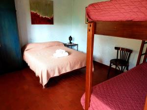 Dormitorio con litera y colcha rosa en Apart Hotel Sahara en Pinamar