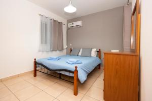 a small bedroom with a bed with blue sheets at Olympia flat 201 in Larnaca