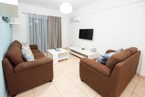 a living room with two chairs and a tv at Olympia flat 201 in Larnaca