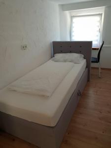 a bed in a small room with a desk at Gasthaus Zur Stadt Triberg in Schonach