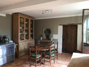 una cucina con tavolo e sedie in legno di La Jauberthie a Vanxains