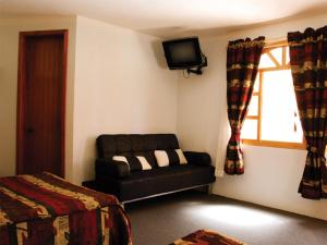 圣克里斯托瓦尔-德拉斯卡萨斯Hotel Arrecife de Coral的带沙发和电视的客厅