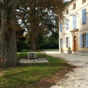 una mesa y sillas junto a un árbol al lado de un edificio en Domaine Christanna, en Lisle-sur-Tarn